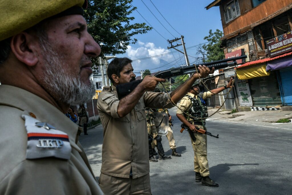 A police officer uses a shotgun to fire pellets at demonstrators on Sept. 7. Photograph by Atul Loke for NY Times