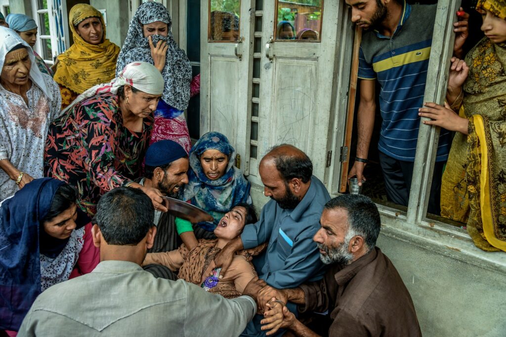 Relatives consoled Zahida Jan, whose brother had been detained, in the Kashmiri city of Pulwama in August. Photography by Atul Loke for NY Times