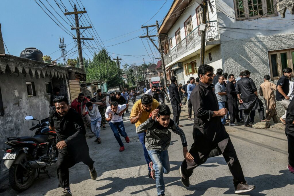 Residents run from the security forces’ tear gas and riot guns in Srinagar on Sept 7. Photo by Atul Loke for NY Times