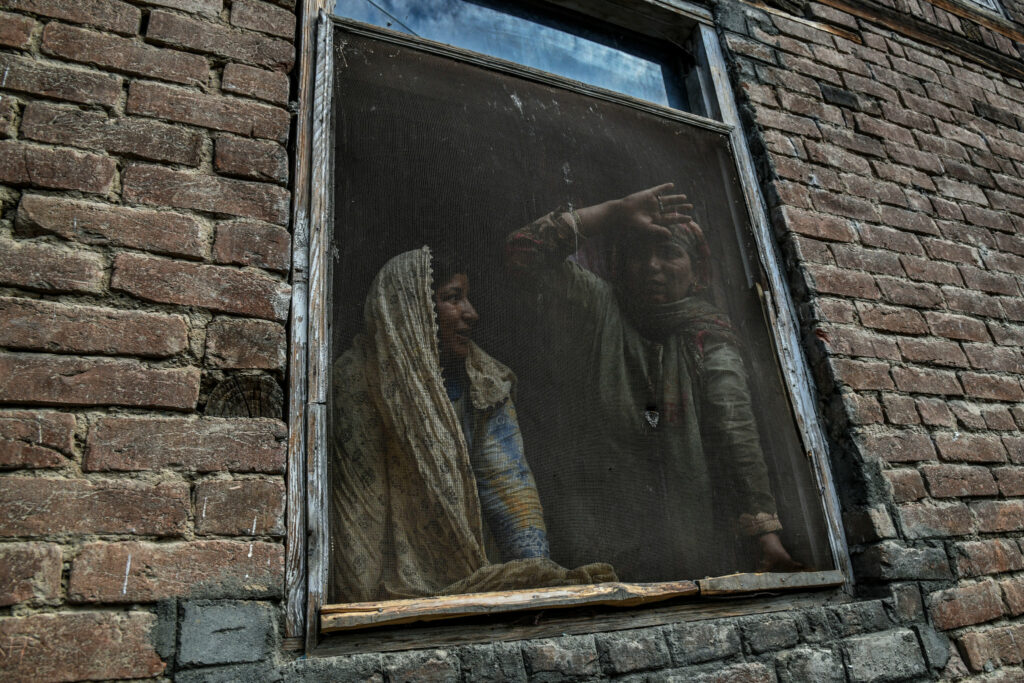 Residents watching a protest in the Soura neighborhood of Srinagar this month. Photo by Atul Loke for NY Times