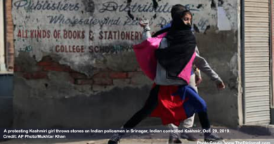 A protesting Kashmiri girl throws stones on Indian policemen