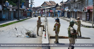 Security personnel stand guard at a check point during restrictions in Sringar