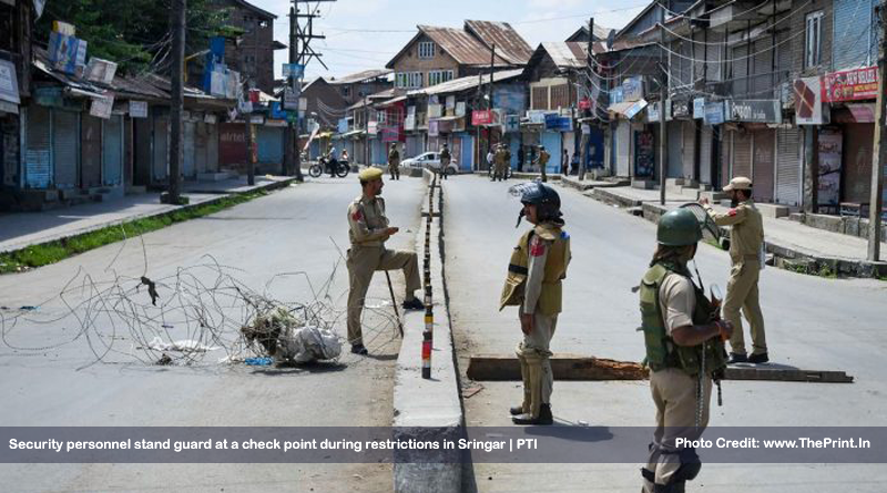 Security personnel stand guard at a check point during restrictions in Sringar