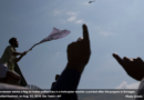 A Kashmiri protester waves a flag as Indian authorities in a helicopter monitor a protest after Eid prayers in Srinagar, Indian controlled Kashmir, on Aug. 12, 2019. Dar Yasin—AP