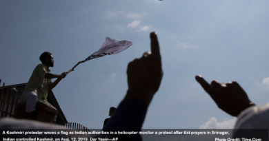 A Kashmiri protester waves a flag as Indian authorities in a helicopter monitor a protest after Eid prayers in Srinagar, Indian controlled Kashmir, on Aug. 12, 2019. Dar Yasin—AP