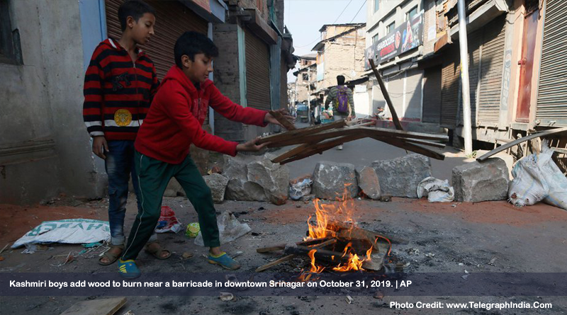 Kashmiri boys add wood to burn near a barricade in downtown Srinagar on October 31, 2019.