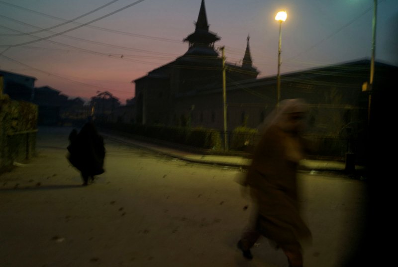 Women make their way home at dusk as clouds of tear gas engulfs the air in the stone strewn streets surrounding the Jama Masjed following riots in Srinagar in Dec. 2008. Alixandra Fazzina—NOOR/Redux