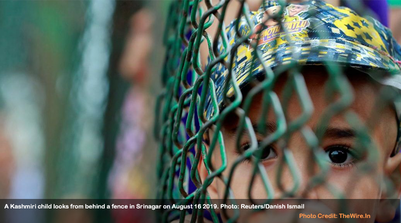 A Kashmiri child looks from behind a fence in Srinagar on August 16 2019