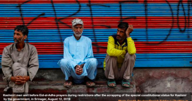 Kashmiri men wait before Eid-al-Adha prayers during restrictions after the scrapping of the special constitutional status for Kashmir by the government