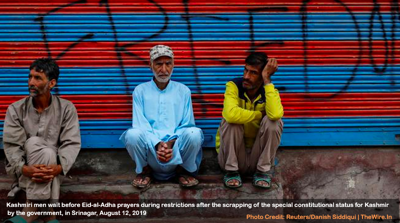 Kashmiri men wait before Eid-al-Adha prayers during restrictions after the scrapping of the special constitutional status for Kashmir by the government